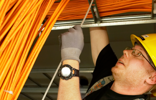 Elektrikar i arbeid, stripser fast kabler