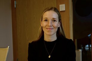 En dame med langt, blond hår. Hun smiler og ser rett i kameraet.