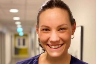 Dame med brunt hår i hestehale og blå t-skjorte. Hun smiler og ser i kamera.