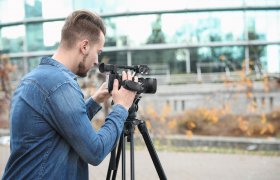  Mann filmer med et lite kamera på et stativ