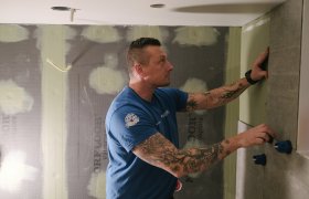 En mur- og flislegger arbeider med store fliser