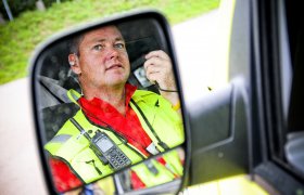 Ambulansearbeider i førersetet på en ambulanse.
