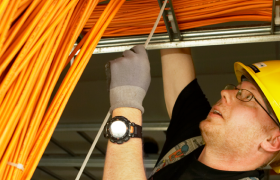 Elektrikar i arbeid, stripser fast kabler