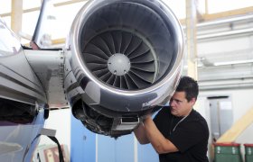Flysystemmekaniker jobber på en propelldel.