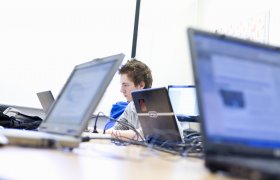 Ung IKT-servicemedarbeidar jobbar på PC.