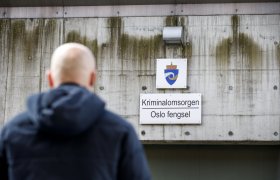 Mann går under skilt kor det står "Kriminalomsorgen – Oslo fengsel".