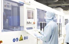 Kjemiker står ved et kontrollpanel i et laboratorium.
