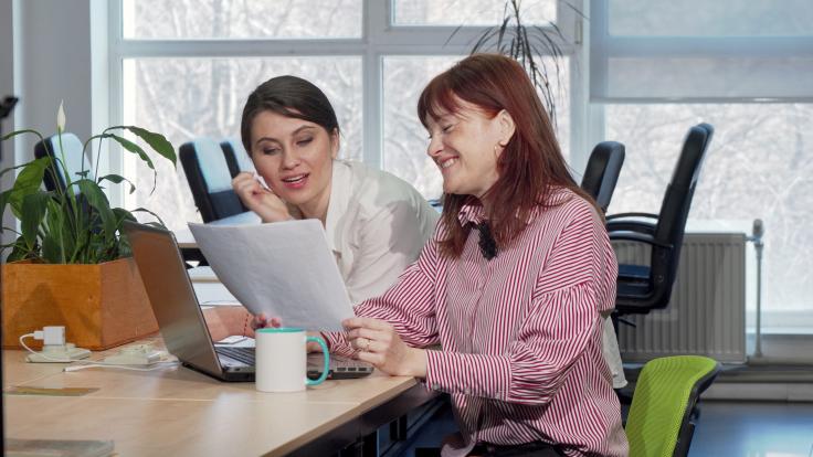 Illustrasjonsbilde fra Colourbox - to damer sitter ved et bord og diskuterer noe fra et papirdokument
