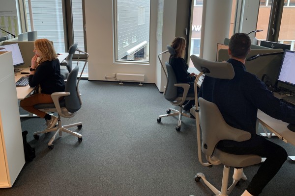 Tre karriereveiledere sitter ved skrivebordet sitt og jobber.