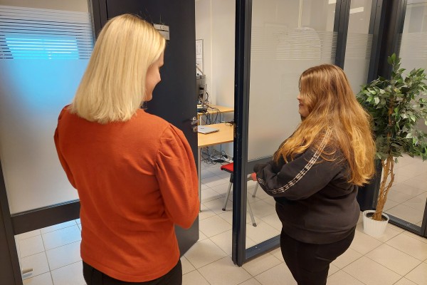 Karriereveileder Marte sammen med en kvinne. De ser på hverandre og står med ryggen delvis mot kamera.