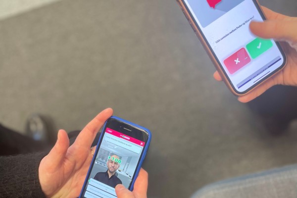 Bilde av to mobiler med hender, på skjermen vises spillet GodKollega