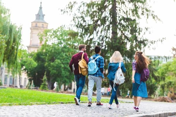 Fire studenter som går mot campus 