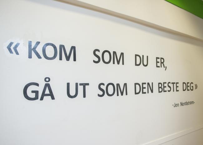 Bilde av sitat på skolevegg som sier «Kom som du er, gå ut som den beste deg»