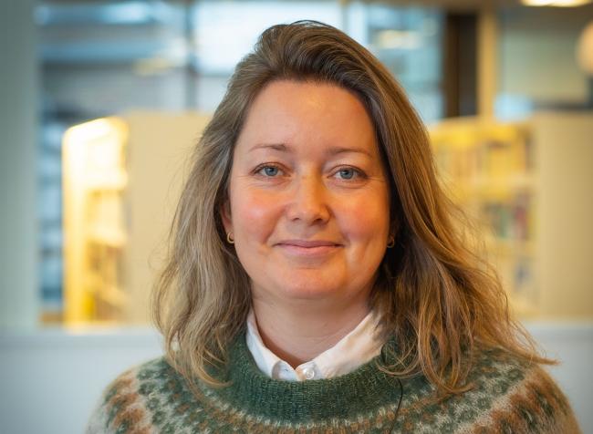 Bilde av blond dame i kontorlandskap